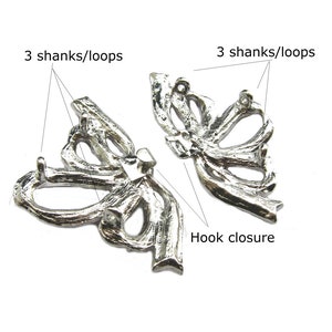 May include: Silver-toned metal butterfly-shaped embellishment with three loops on each side and a hook closure.  3 Shanks/Loops.