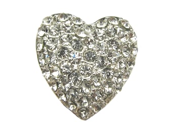 Pode incluir: Um broche de coração prateado coberto de strass transparentes.