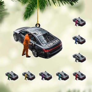 May include: A black car ornament with a person washing the car, with the text "YOUR TEXT" on the back. Additional ornaments show the same car with different colored figures washing the car. The ornament hangs from a gold string.