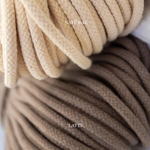 May include: Close-up of two spools of thick, twisted cotton rope. The top spool is a natural, off-white colour with the word "NATURAL" printed on it. The bottom spool is a latte brown colour with the word "LATTE" printed on it.
