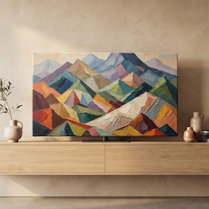 May include: A rectangular television screen displaying a vibrant, textured oil painting of a mountain range with peaks in shades of blue, purple, orange, green, and white. The screen is mounted on a long, light-toned wooden floating console.