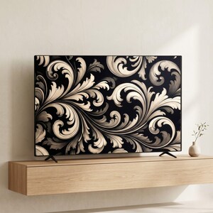 May include: A flat-screen television displaying a black background with a repeating cream-colored acanthus leaf scroll pattern. The television is mounted on a light-toned wooden floating shelf, with a small white vase placed to the right side.
