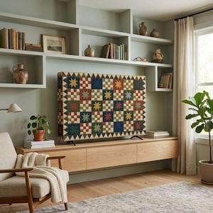 Puede incluir: Una pantalla de televisión que muestra un patrón de colcha con una cuadrícula de estrellas multicolores en tonos rojo, azul, verde y amarillo, sobre un fondo claro con un diseño de borde geométrico repetitivo.