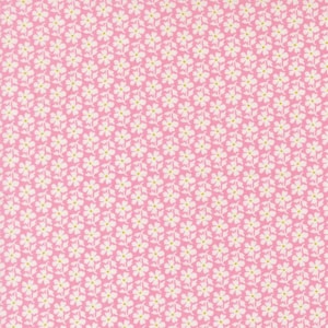 May include: Pink fabric with a repeating pattern of small white flowers with yellow centers and green stems. The floral design covers the entire surface, creating a dense, textured appearance. The fabric has a subtle, woven texture.