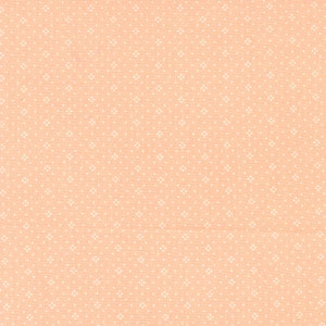 May include: Peach-colored fabric with a repeating pattern of small white floral-like shapes. The fabric has a slightly textured appearance, suggesting a woven material. The overall design is simple and classic, suitable for various sewing projects.