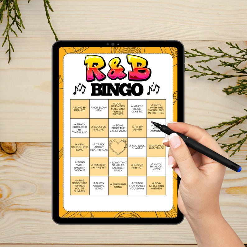 Puede incluir: Un juego de Bingo R&B que se muestra en una tableta. El tablero del juego presenta un dise&ntilde;o colorido con el texto "R&B Bingo" y varias indicaciones relacionadas con la m&uacute;sica. Una mano con un bol&iacute;grafo se&ntilde;ala el tablero.
