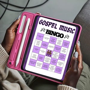 May include: A pink tablet case holding a tablet with a Gospel Music Bingo game displayed on the screen. The game board features various gospel music-related phrases. A white stylus is attached to the case.