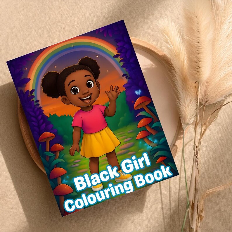 Peut inclure: Un livre de coloriage intitul&eacute; "Black Girl Colouring Book" avec une illustration de dessin anim&eacute; d'une jeune fille noire souriante avec un arc-en-ciel en arri&egrave;re-plan. La fille porte un haut rose, une jupe jaune et des chaussures jaunes. Le livre est sur un plateau en bois.