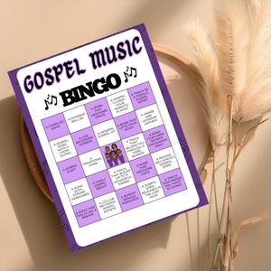 May include: A purple and white Gospel Music Bingo game card. The card features a grid of bingo squares with phrases like "A Worship Ballad" and "A Song That Mentions Grace." The words "Gospel Music Bingo" are at the top.