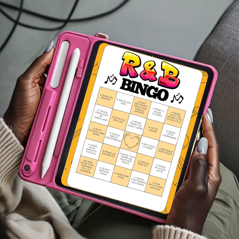 Puede incluir: Una funda de tableta rosa sostiene una tableta que muestra un juego de Bingo de R&B. El tablero del juego presenta una cuadr&iacute;cula de casillas con indicaciones relacionadas con canciones. La tableta la sostiene una persona de piel oscura. Un l&aacute;piz &oacute;ptico es visible.