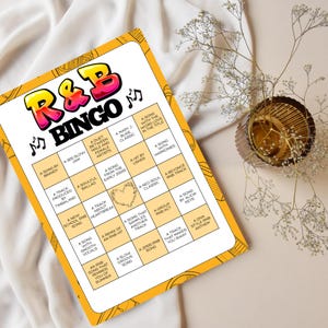 Puede incluir: Una tarjeta de juego de bingo R&B con borde amarillo e interior blanco. El t&iacute;tulo "R&B BINGO" est&aacute; en letras grandes y coloridas. La tarjeta presenta varios temas de R&B, como "Una canci&oacute;n de Brandy" y "Un dueto entre artistas masculinos y femeninos".