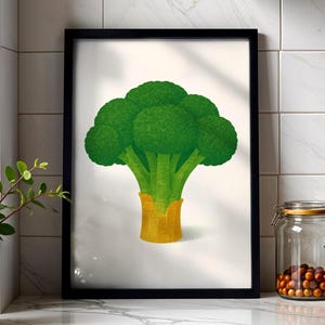 Könnte beinhalten: Gerahmter Kunstdruck mit einer detaillierten Illustration eines grünen Brokkolikopfes mit gelbem Sockel. Das Kunstwerk ist vor einem weißen Hintergrund platziert und in einem schwarzen Rahmen eingefasst. Das Bild ist ein Stillleben eines Gemüses.