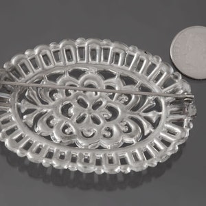 K&ouml;nnte beinhalten: Silberne Filigranbrosche mit floralem Design. Die Brosche hat eine Nadel und einen Verschluss auf der R&uuml;ckseite.