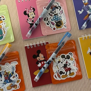 May include: A white ceramic mug with a black handle and the text "But First, Coffee" in a black, bold font. The mug is on a white surface.