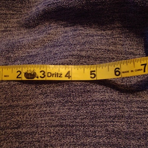 Könnte beinhalten: Ein gelbes Maßband mit schwarzen Zahlen und den Worten "Dritz" und "Made in China". Das Band misst 20,3 cm.