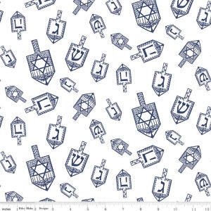 May include: A white fabric with a repeating pattern of blue dreidels. The dreidels have different Hebrew letters and symbols on them.