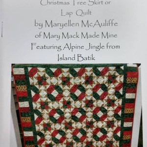 Könnte beinhalten: Ein Quiltmuster namens "Jack's Star" Christbaumrock oder Schoßdecke von Maryellen McAuliffe von Mary Mack Made Mine mit Alpine Jingle von Island Batik. Der Quilt ist aus rotem, grünem und goldenem Stoff gefertigt und hat ein Sternenmuster.