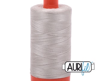 May include: A spool of silver gray thread with an orange plastic bobbin and the Aurifil logo on the side.