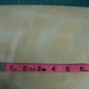 May include: A close-up of a pink measuring tape with black markings. The tape reads "1 inch, 2 Dritz, 3, 4, 5, 6, 7, Made in China".