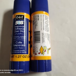 May include: Two blue and yellow glue sticks with the brand name "Odif" and the product name "505 Temporar Adhesive Glue Stick for fabric". The glue sticks are labelled "1.27 oz (36g)".