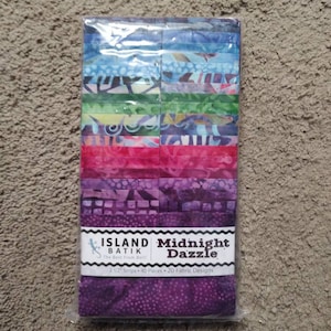 May include: A package of 40 2.5 inch fabric strips in a variety of colors and patterns. The fabric is batik and the package is labeled "Island Batik Midnight Dazzle".