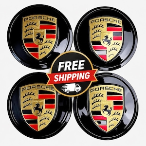 May include: Four black car wheel center caps with the Porsche logo. Each cap features a gold, red, and black emblem with the Porsche crest. The caps are round and glossy, with the word "PORSCHE" in gold lettering.