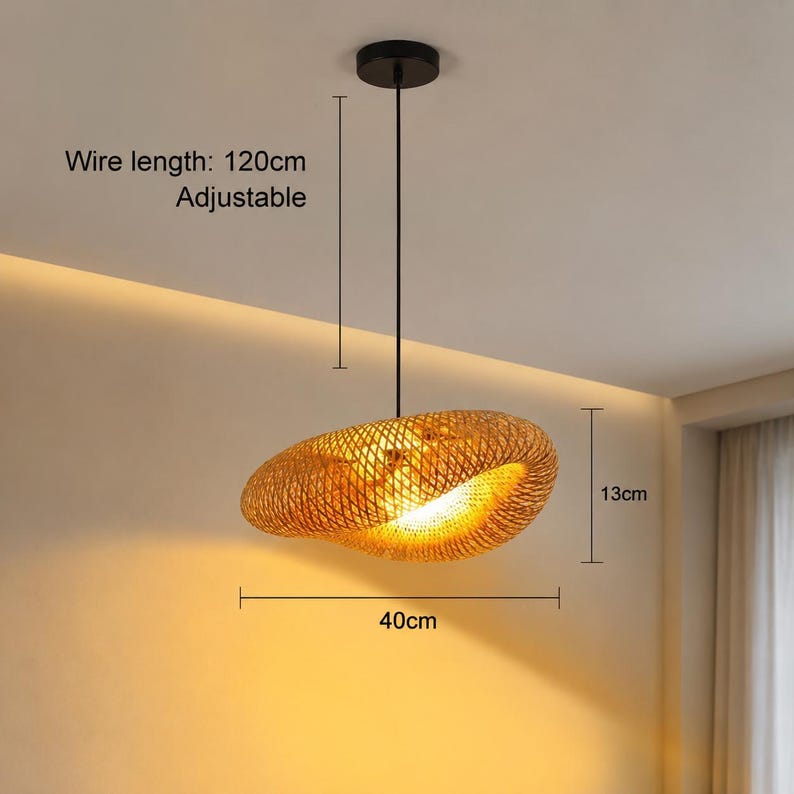 Puede incluir: Una l&aacute;mpara colgante de bamb&uacute; trenzado con una forma org&aacute;nica irregular. El accesorio cuenta con un soporte de techo negro y un cable ajustable de 120cm. La pantalla mide 40cm de ancho y 13cm de alto, emitiendo un brillo c&aacute;lido y dorado.