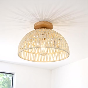 May include: A woven, dome-shaped ceiling light fixture with a natural wood base. The light fixture is made of a light beige material and has a woven pattern.