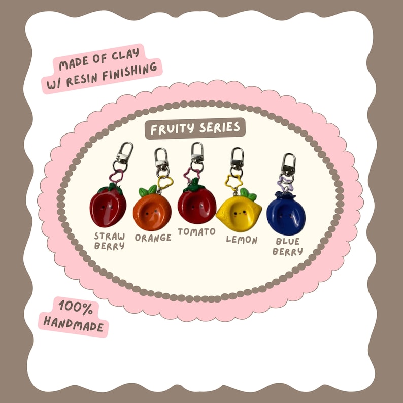 May include: Handmade clay keychains from the Fruity Series, featuring a strawberry, orange, tomato, lemon, and blueberry. Each keychain has a silver-colored clasp. The keychains are made of clay with resin finishing.