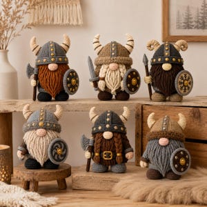 Peut inclure: Six figurines de gnomes au crochet habillées en Vikings, portant chacune un casque à cornes avec des clous de couleur métallique. Les gnomes ont de longues barbes en laine et tiennent une petite arme au crochet, hache ou épée, et un bouclier rond.