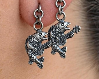 Pendientes Medieval Marginalia con diseño de pez: Pendientes hechos a mano en plata de ley 925 con un original pez medieval tocando un instrumento.