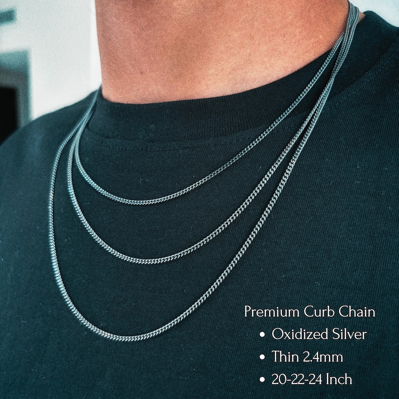 May include: Three layered oxidized silver curb chains with a thin 2.4mm width. The text on the image reads: Premium Curb Chain, Oxidized Silver, Thin 2.4mm, 20-22-24 Inch. The chains are displayed against a plain black fabric background.