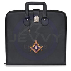 May include: Black leather briefcase with a silver clasp and handle. Features a purple and gold Masonic emblem. Includes a small key and the text "JEVVY CRAFTS".