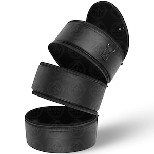 Può includere: Custodia per cappelli in pelle nera con tre scomparti impilati, ciascuno con chiusura a cerniera. La sezione superiore è aperta, rivelando l'interno. Una piccola maniglia è attaccata alla sezione superiore. La custodia è progettata per proteggere e conservare i cappelli.