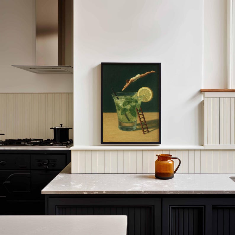 Pu&ograve; includere: Una stampa artistica incorniciata raffigura un cocktail mojito con un subacqueo. L'opera presenta una fetta di limone, foglie di menta e una piccola scala di legno. Lo sfondo &egrave; verde scuro e la cornice &egrave; nera.