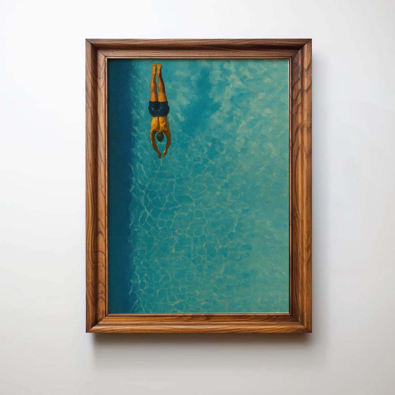 May include: A framed art print depicts a person diving headfirst into a turquoise pool. The artwork features a top-down perspective, with the diver's body and the water's surface visible. The frame is made of wood.