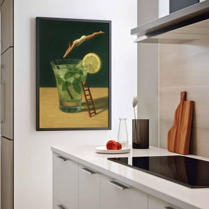 Pu&ograve; includere: Una stampa artistica incorniciata raffigura una persona che si tuffa in un cocktail mojito. L'opera presenta uno sfondo verde, un bicchiere pieno di menta e ghiaccio, una fetta di limone e una piccola scala di legno. L'opera &egrave; esposta in una cucina moderna.