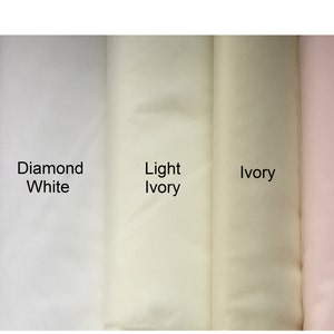 K&ouml;nnte beinhalten: Stoffmuster in verschiedenen Wei&szlig;- und Off-White-T&ouml;nen, darunter Wei&szlig;, Diamantwei&szlig;, Hellelfenbein, Elfenbein und Blush. Die Farbbezeichnungen sind auf dem Stoff angegeben.