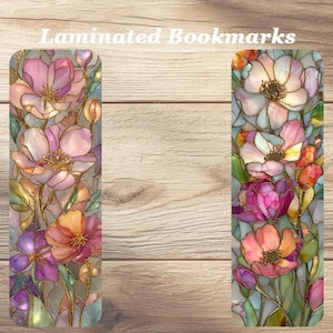 May include: Two laminated bookmarks with floral designs. The bookmarks feature colorful flowers in shades of pink, orange, and purple, with green leaves and stems. The text "Laminated Bookmarks" is at the top.