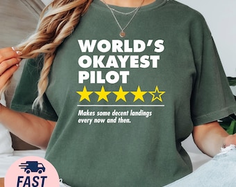 May include: Dark green t-shirt with the text "WORLD'S OKAYEST PILOT" in white, along with a rating of four and a half stars in yellow. The shirt also includes the phrase "Makes some decent landings every now and then."