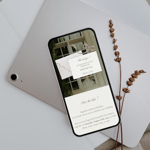 May include: A smartphone displaying a digital wedding invitation with the text She said yes! You're invited to our wedding on August 26th, 2027, and Save the date! Together with our families, we warmly invite you to celebrate our wedding.
