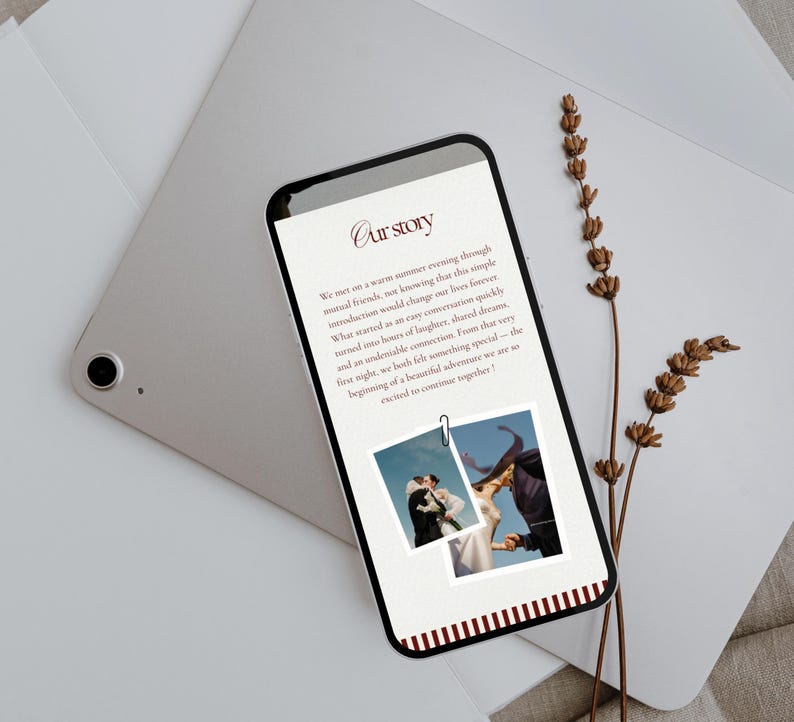 May include: A smartphone displays a wedding story with the title "Our Story" in a script font. Two photos are attached with a paper clip. The phone rests on a silver tablet and a white envelope, with dried flowers nearby.