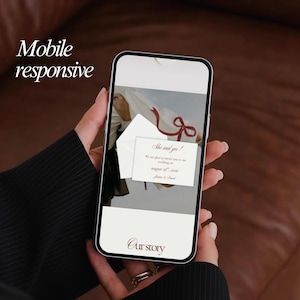 May include: A smartphone displays a wedding invitation with the text "She said yes!" and "August 26, 2026." The phone is held in a person's hand, with the words "Mobile responsive" and "Our story" visible.