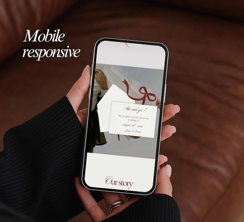 May include: A smartphone displays a wedding invitation with the text "She said yes!" and "August 26, 2026." The phone is held in a person's hand, with the words "Mobile responsive" and "Our story" visible.