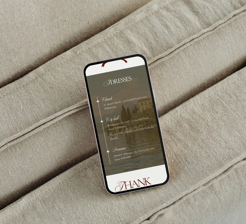 May include: A smartphone displaying a list of locations for dresses, including a church, city hall, and a domaine. The screen has a scenic background and the word "THANK" at the bottom. The phone rests on a beige fabric.