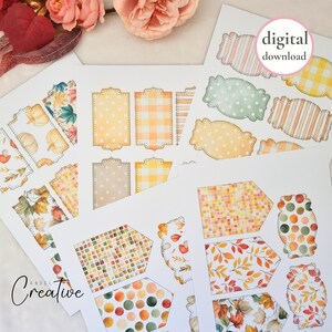 May include: A collection of printable digital download tags and labels with autumn-themed designs. The tags feature various patterns, including polka dots, gingham, and leaf motifs, in warm colors like orange, yellow, and brown. The text "digital download" is visible.