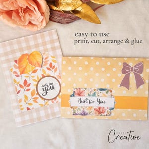 May include: Two handmade greeting cards with fall-themed designs. One card features a leaf pattern and the text "Just for you." The other card has a polka dot background, a bow, and the text "Just for You."