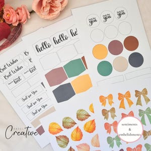 May include: A collection of printed paper sheets featuring sentiments and embellishments. Designs include bows, leaves, and color swatches in shades of orange, green, and brown. Text includes "hello", "Best Wishes", and "Just for You".