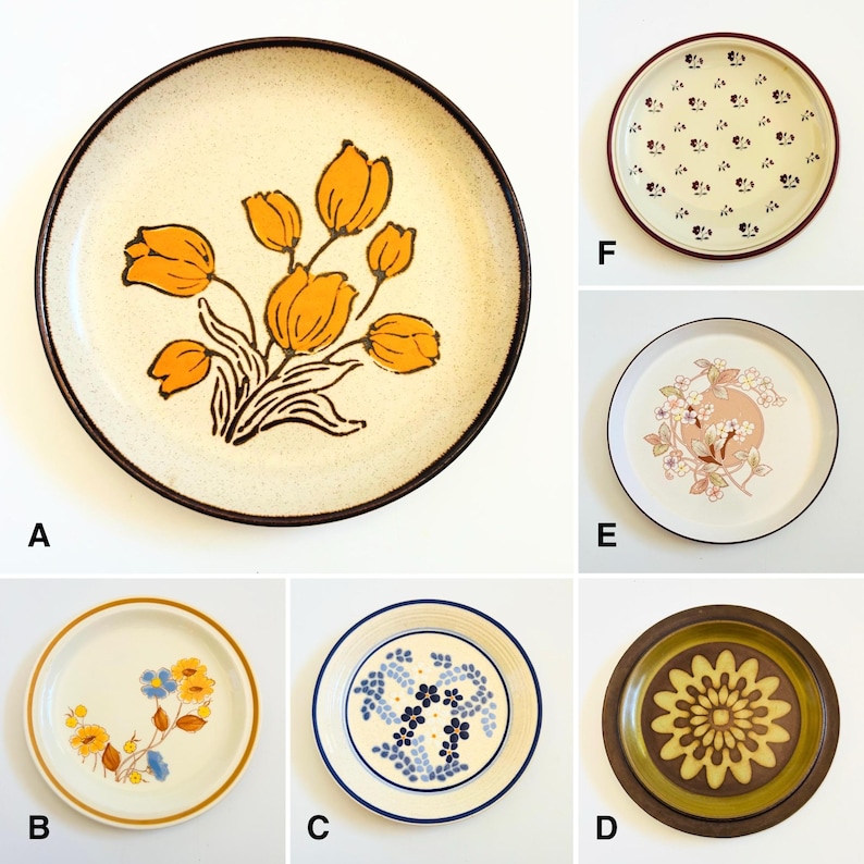 K&ouml;nnte beinhalten: Eine Sammlung von sechs Vintage-Keramikplatten. Platte A zeigt ein orangefarbenes Tulpenblumendesign auf cremefarbenem Hintergrund mit braunem Rand. Andere Teller haben Blumen- und geometrische Muster in verschiedenen Farben, darunter Blau, Gelb und Braun. Ideal f&uuml;r die K&uuml;chendekoration.