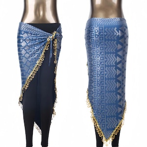 Puede incluir: Falda envolvente azul y plateada con ribete de monedas doradas. La falda se combina con leggings negros. La tela tiene un diseño geométrico. La falda está diseñada para usarse alrededor de la cintura.